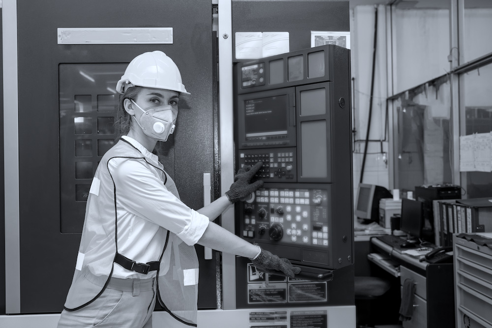 Female Mechanic wearing  protective mask to Protect Against Covid-19,Female technician worker working and checking machine in a large industrial factory,Coronavirus has turned into a global emergency