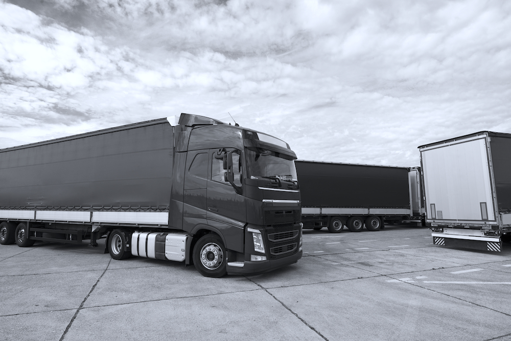 Truck vehicle with trailers in background.