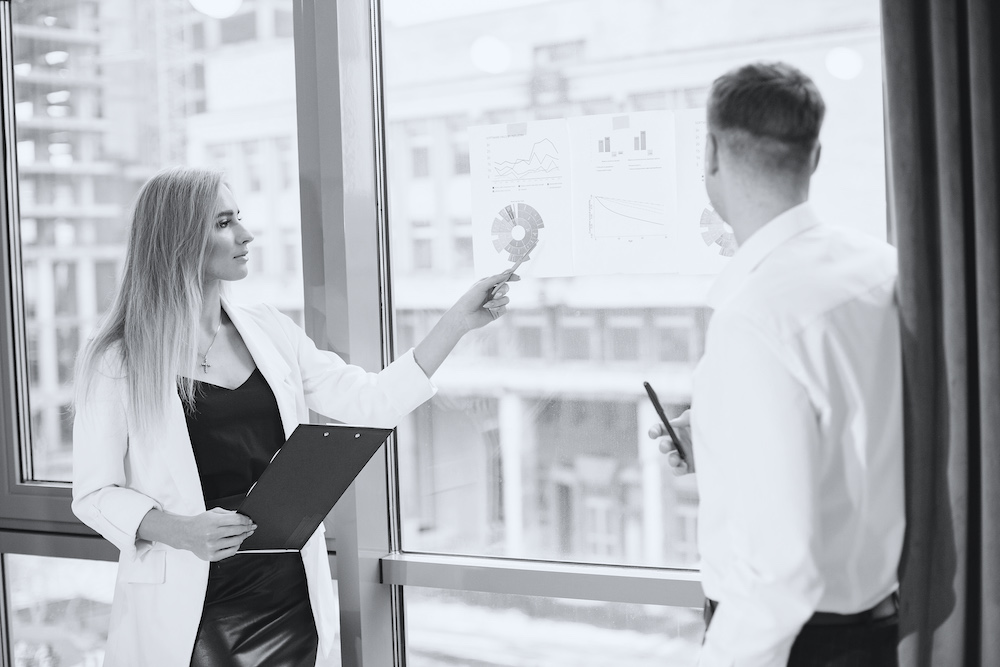 Young people working together and standing by the window