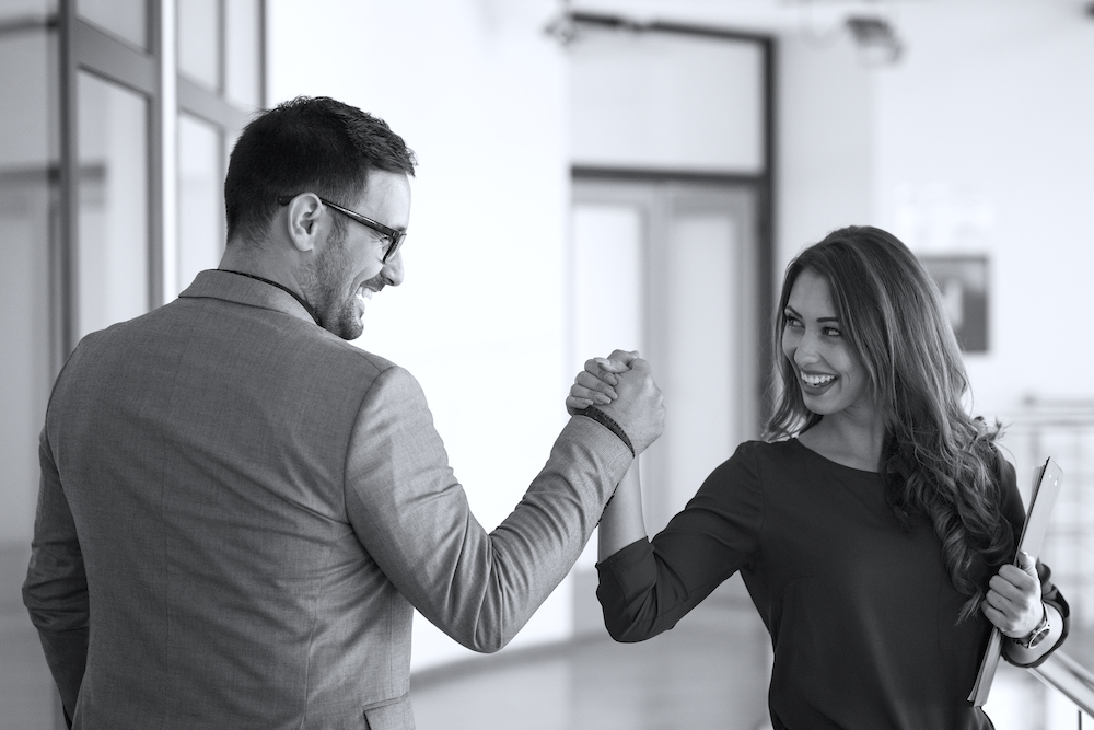 Young successful business people greeting in company’s office.